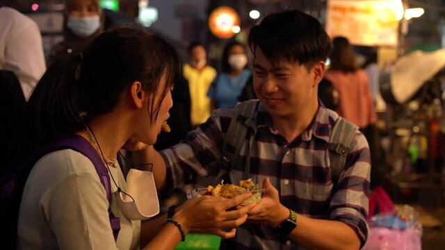 Happy couple eating street food at Thailand