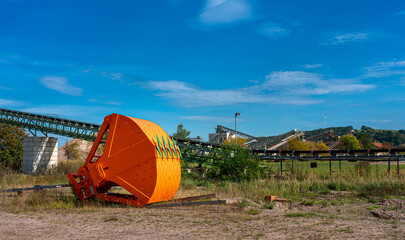excavator bucket in orange on an industrial site