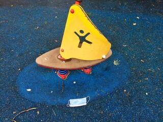 Masque jeté dans une aire de jeux pour enfant pendant la pandémie du Covid-19