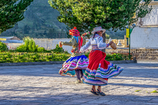 Peru, in the village of Chivay near the Colca Canon , 
joung girls dancing in traditional dresses around a fountain 