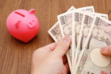 ピンクの豚の貯金箱と日本の1万円札