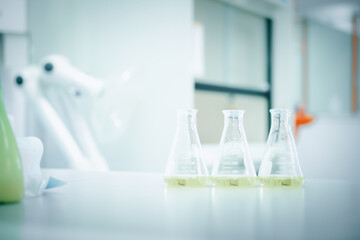 Laboratory flask with colorful liquids stirred inside in laboratory