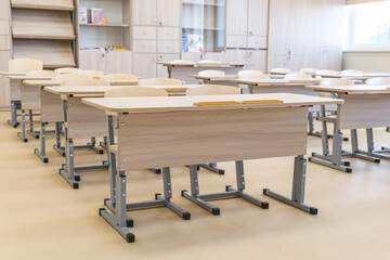 School classroom closed in background without young student, school desks