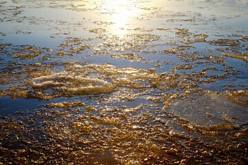 Background of sea with cracked ice crystals in the colorful frosty sunset, Baltic sea, cold time