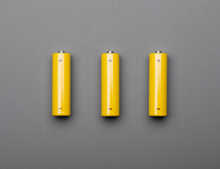 Yellow AA alkaline batteries on gray background colors of the year 2021 concept