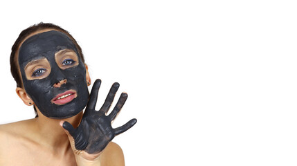 Beautiful girl with cosmetic mud mask shows her hands
