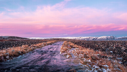 Icy winter road through the tundra in Teriberka. Amazing colorful Arctic landscape