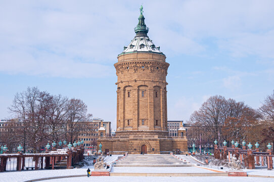 Mannheim, Germany. January 31th, 2010. A person is standing in front of the Wasserturm (Water Tower) at the Friedrichsplatz after a snowfall at the end of January.