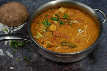 Vegan thai red curry  sauce with tofu, radddish and carrot in stainless steel pan