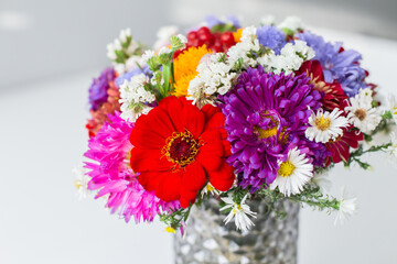 A bouquet of multi-colored flowers in a glass vase