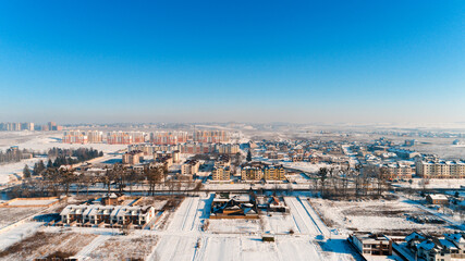 Top view of the winter village with snow covered houses and roads. Aerial view of landscape