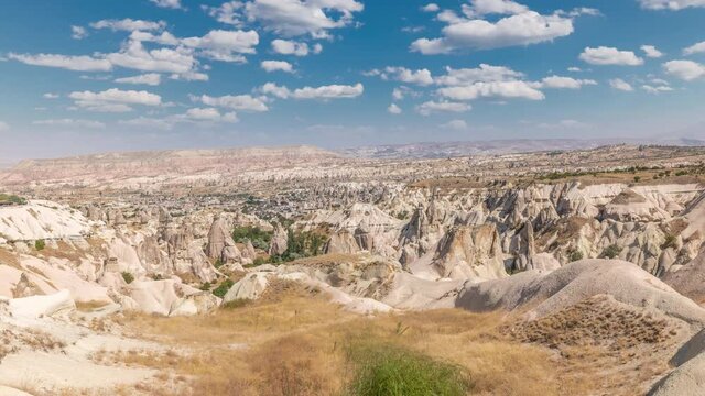 Red Valley and Rose Valley of Goreme of Nevsehir in Cappadocia aerial timelapse, Turkey. Love valley and fairy chimneys panoramic view with clouds on a blue sky