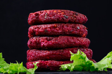 Vegan beet burgers in a stack against the dark background. Healthy alternative. Low key photo