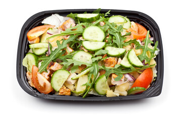 Take away chicken salad in a black plastic box. Studio photo isolated on white background.