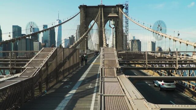 View of the Brooklyn Bridge main arch with city skyline in the background - Crane up Slow motion