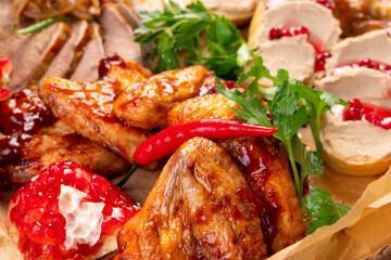 barbecue wings close - up on the background of snacks. Garnished with chili peppers and herbs. Catering box. Delivery of snacks.