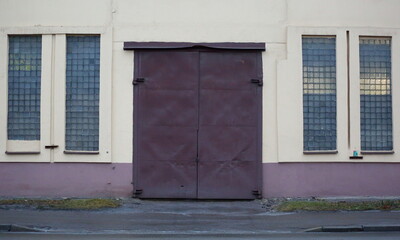 Metal gate in the wall with narrow Windows