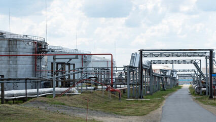 Obraz premium Refinery factory oil storage tank and pipeline steel at day on framatic sky background. Oil refinery plant from industry zone. Ecosystem and healthy environment concepts.