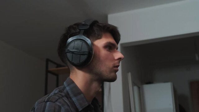 Vocal studio recording. Man puts on headphones before singing in music studio.