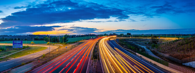 Colorful sunset at M1 motorway near Flitwick junction with cars light trails. United Kingdom
