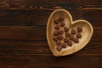 Obraz na płótnie Canvas Chocolates hearts on brown wooden background. Top view. Copy space. Valentines day celebration concept