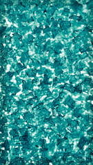 Fototapeta na wymiar Blue green wallpaper for a mobile phone. Abstract vertical winter background. Ice crystals on the window pane close-up. Dark turquoise or cyan tinted backdrop with vignetting frame. Macro