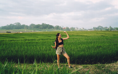 Positive woman standing in green field