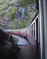 Kuranda scenic railway going past waterfalls through tropical rainforest
