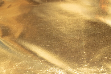 Golden sparkling Christmas background. Crumpled fabric texture, soft focus