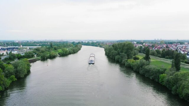 Aerial drone view following a freight transport ferry, Inland waterway shipping on Main river, in Germany