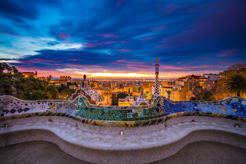 Fototapeta na wymiar Beautiful sunrise in Barcelona seen from Park Guell. Park was built from 1900 to 1914 and was officially opened as a public park in 1926. In 1984, UNESCO declared the park a World Heritage Site
