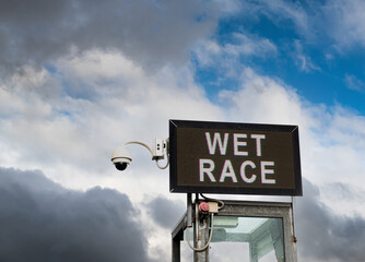 Wet race announcement text motorsport sign low angle view with cloudy sky in background