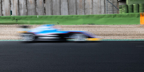 Fototapeta na wymiar Speed concept blurred motion racing car on asphalt track side view