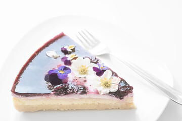 Blueberry Cheesecake Slice On A Plate Decorated With Spring Flowers Ready To Eat | Cake Topping | Homemade sugary food | Slice Of Cake On A Plate | Minimalist Photography | Airy And Bright