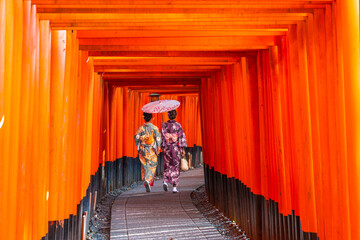 Obraz premium Women in traditional japanese kimonos walking at Fushimi Inari Shrine in Kyoto, Japan
