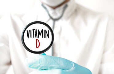 Doctor holding a stethoscope with text VITAMIN D, medical concept