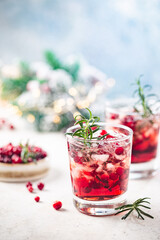 Refreshing drink with cranberries and rosemary on white background