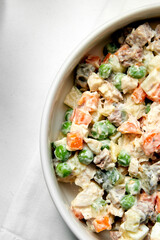 Russian traditional salad Olivier with vegetables and meat