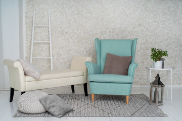 Classical interior of a white room with white sofa, pillows, lantern and turquoise or cyan armchair.