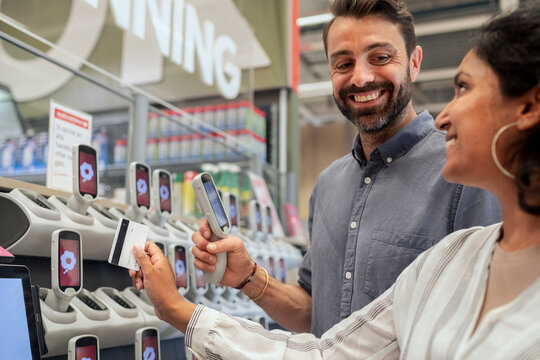 Couple holding barcode reader in supermarket