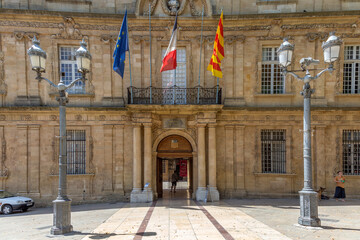 facade of Hotel de Ville in Aix en Provence with French, local and european Flag