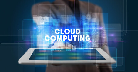 Young business person working on tablet and shows the inscription: CLOUD COMPUTING