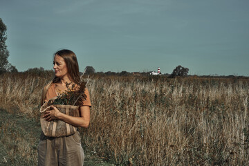 The woman collects flowers in the field. Biodegradable bag.