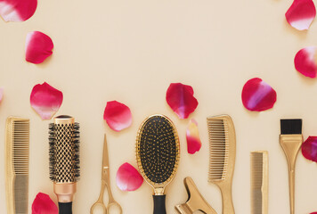 Hairdressing tools in gold color and rose petals on a beige background with space for text. Banner, Valentine card or template for hair salon information.