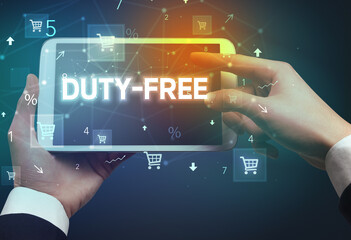 Close-up of a hand holding tablet with DUTY-FREE inscription, online shopping concept