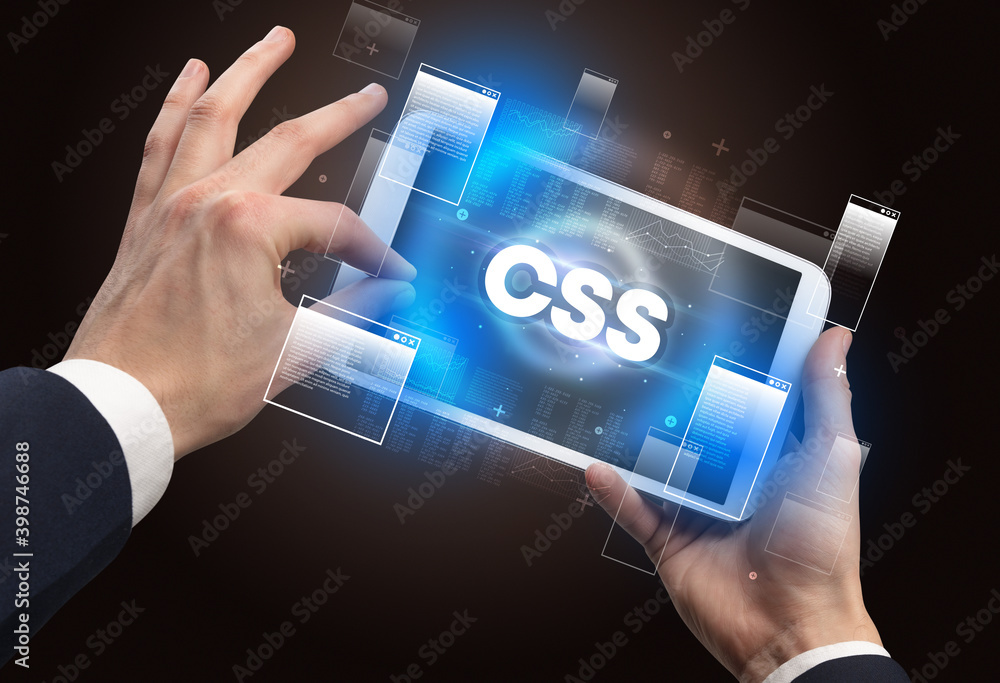 Poster close-up of a hand holding tablet with css abbreviation, modern technology concept