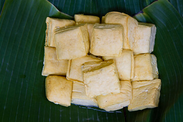 close up of white tofu on banana leaf