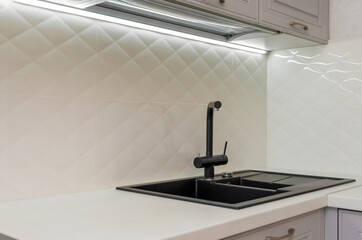 Beautiful interior of a classic kitchen in light gray and white colors with led lighting