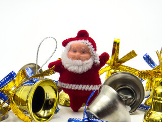 three funny santa claus toys with christmas bells on white background. In focus and out of focus
