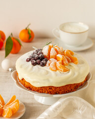 Christmas cake with tangerines, cranberry and rosemary on a stand 